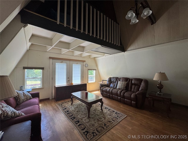 living area featuring vaulted ceiling with beams, french doors, a wealth of natural light, and wood finished floors