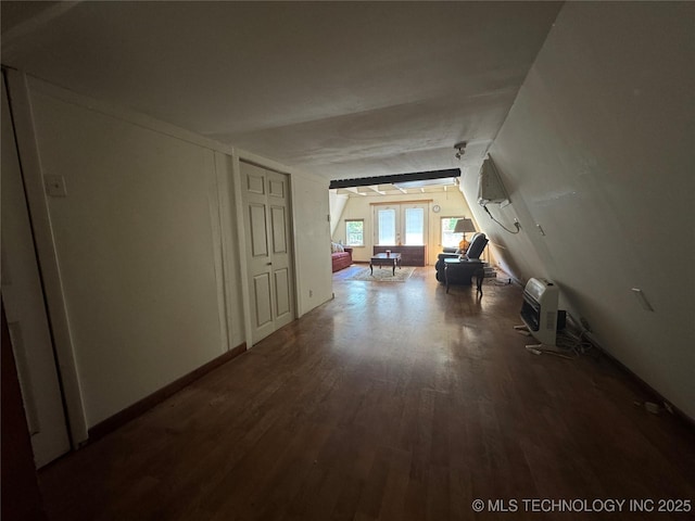 hallway with heating unit, wood finished floors, and lofted ceiling