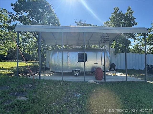 view of car parking featuring fence and a carport