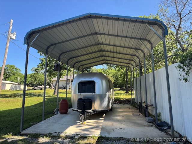 view of parking / parking lot featuring fence and a detached carport