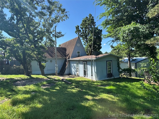 back of house with fence and a yard