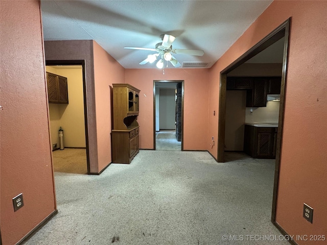 interior space with carpet floors, ceiling fan, and visible vents
