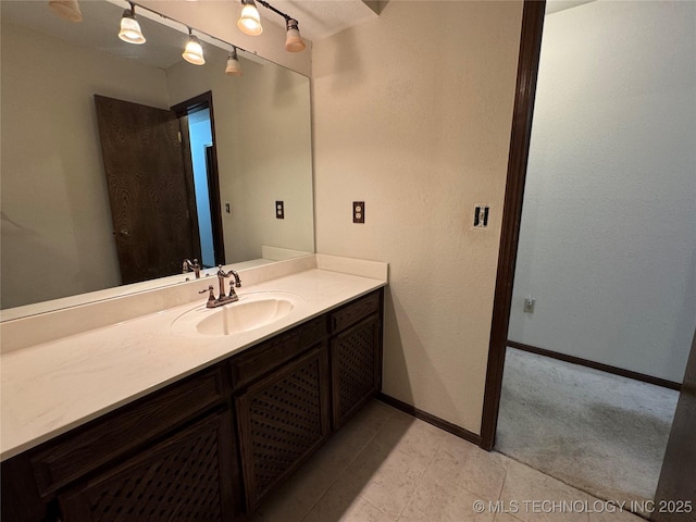 bathroom with vanity, baseboards, and tile patterned flooring