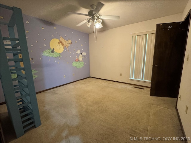 unfurnished bedroom featuring carpet floors, a textured ceiling, baseboards, and visible vents