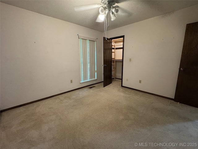 unfurnished bedroom with ceiling fan, light carpet, baseboards, visible vents, and a closet