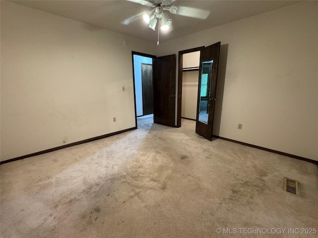 unfurnished bedroom featuring baseboards, light carpet, a closet, and visible vents