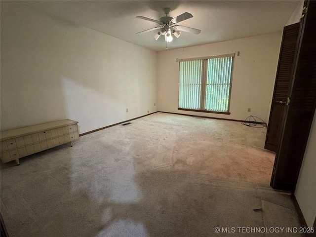 unfurnished room with baseboards, ceiling fan, carpet floors, and visible vents