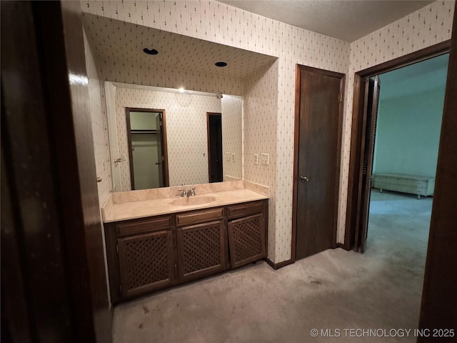 bathroom featuring vanity and wallpapered walls