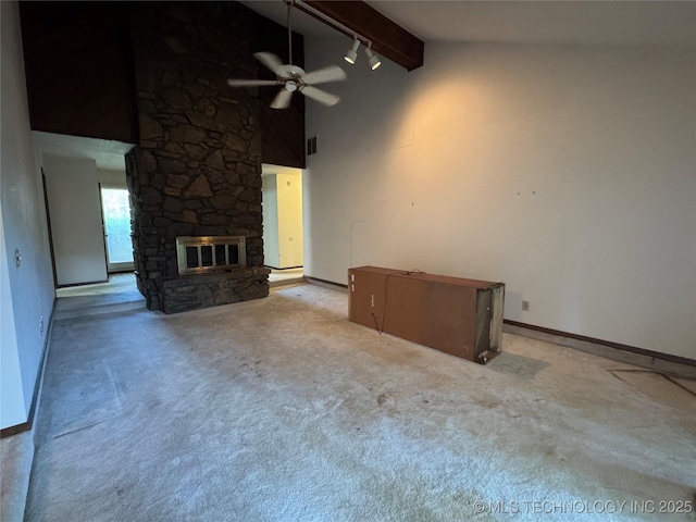 unfurnished living room with a fireplace, beamed ceiling, baseboards, a ceiling fan, and carpet