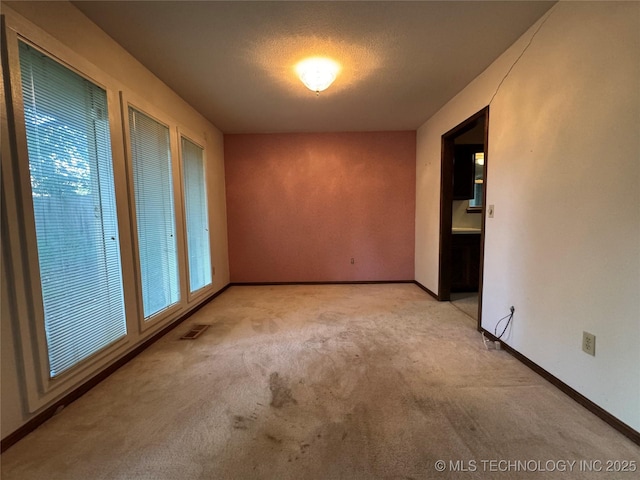 unfurnished room with baseboards, carpet flooring, and visible vents