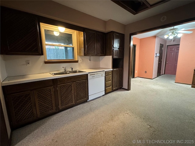 kitchen featuring ceiling fan, light colored carpet, dishwasher, a sink, and light countertops