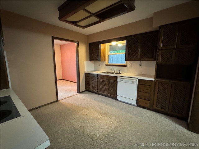kitchen featuring light carpet, a sink, dishwasher, light countertops, and black electric cooktop