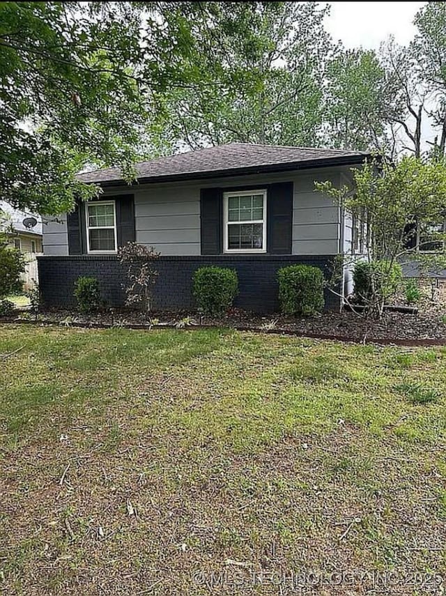 ranch-style home with brick siding and a front lawn