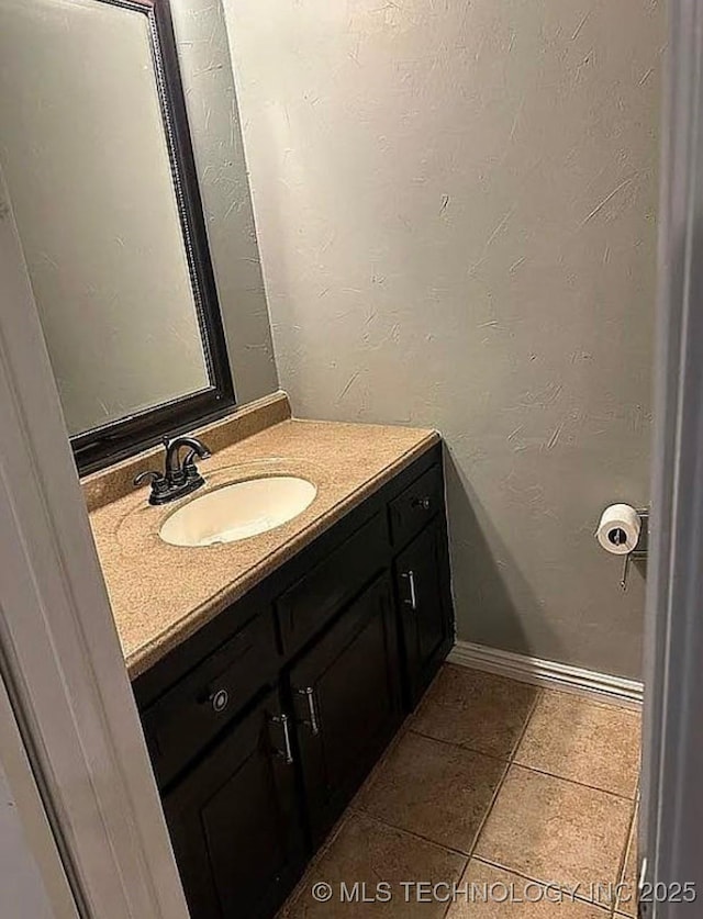 bathroom featuring baseboards, tile patterned flooring, and vanity