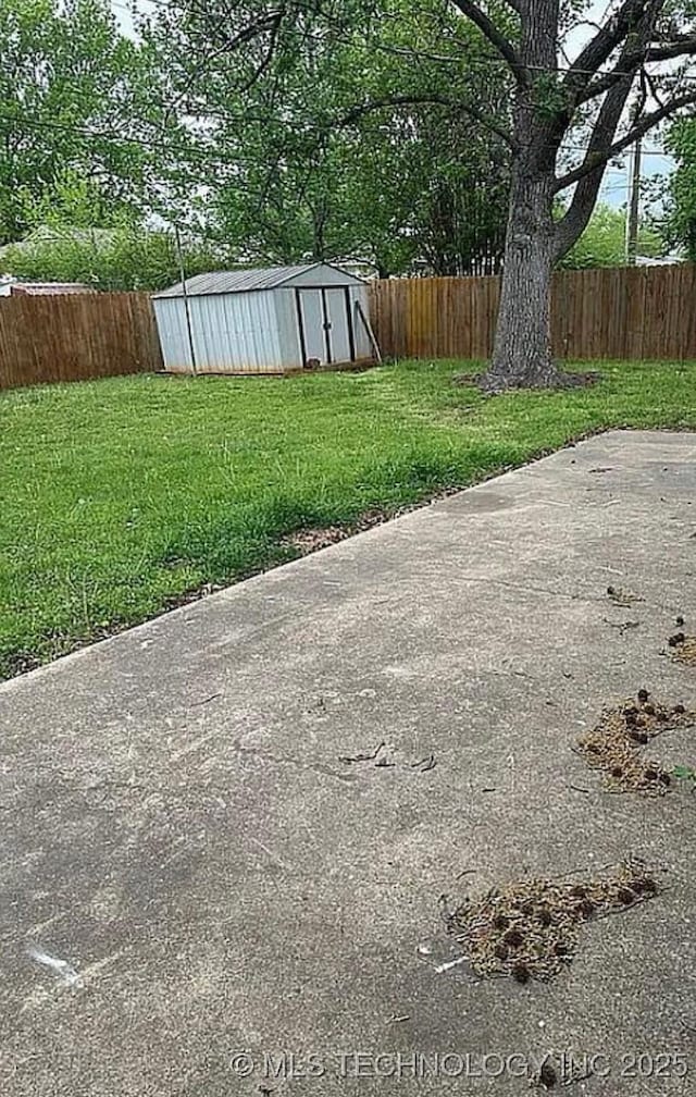 view of yard featuring a storage shed, an outdoor structure, and a fenced backyard