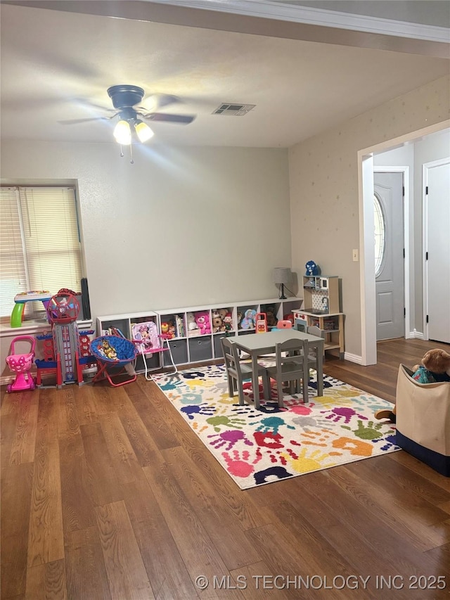 recreation room with visible vents, a ceiling fan, and wood finished floors