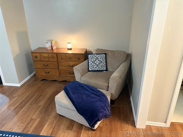 living area with baseboards and wood finished floors