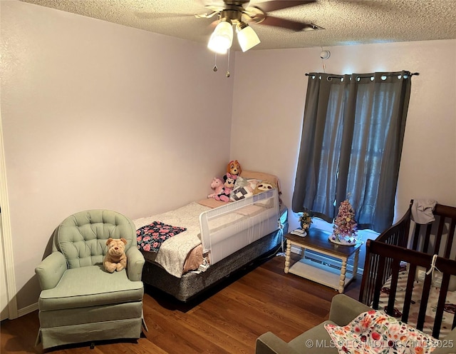 bedroom with a textured ceiling, ceiling fan, and wood finished floors