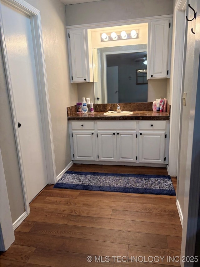 bathroom with vanity, baseboards, and wood finished floors