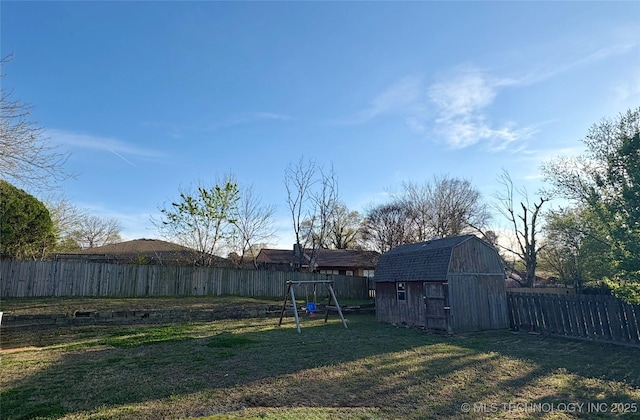 view of yard featuring a fenced backyard, a storage unit, and an outdoor structure