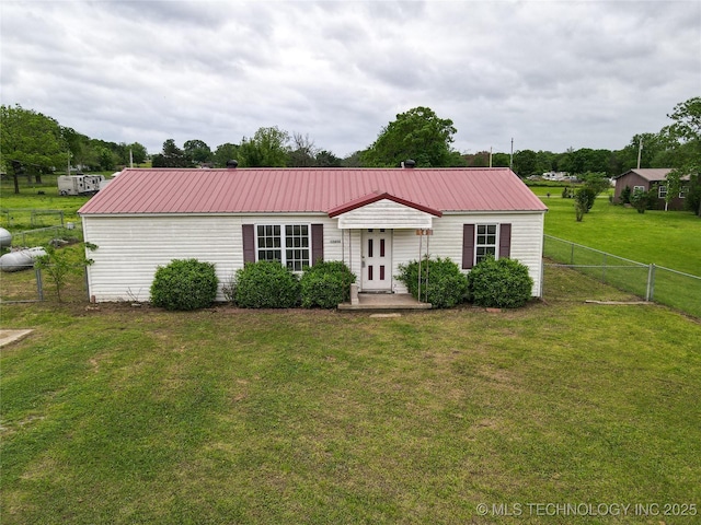 ranch-style home featuring fence, a front lawn, metal roof, and french doors