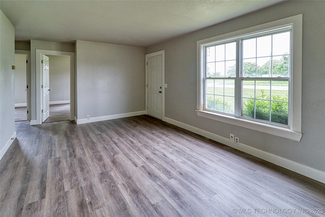 empty room with baseboards and wood finished floors