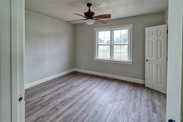 unfurnished bedroom with baseboards, ceiling fan, and wood finished floors