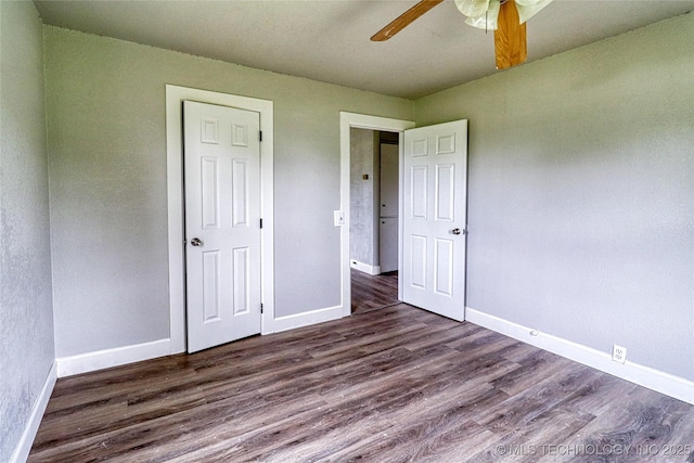 unfurnished bedroom with baseboards and dark wood finished floors
