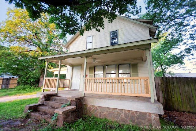 view of front of home featuring fence, ceiling fan, and a porch
