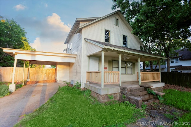 country-style home featuring fence, a carport, a porch, and driveway