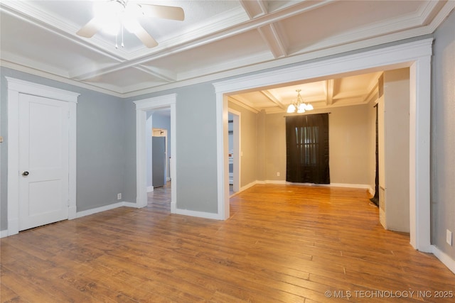 spare room with crown molding, wood finished floors, baseboards, ceiling fan with notable chandelier, and coffered ceiling