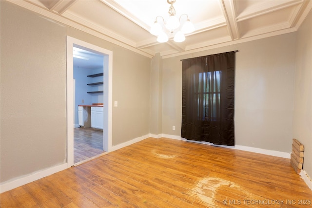 spare room featuring light wood-type flooring, baseboards, beamed ceiling, a notable chandelier, and coffered ceiling