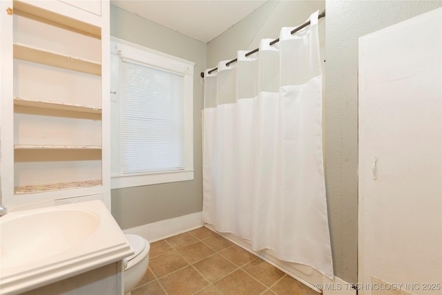 full bath with a sink, toilet, and a shower with shower curtain