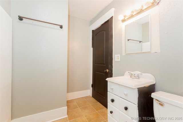 half bath with vanity, tile patterned flooring, and toilet