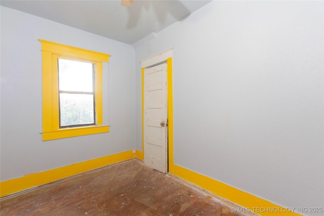 empty room featuring baseboards, ceiling fan, and wood finished floors