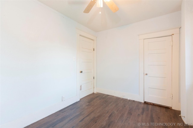 spare room featuring dark wood-type flooring and a ceiling fan