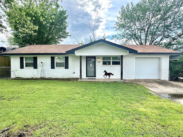 ranch-style home featuring a garage, concrete driveway, a front yard, and brick siding