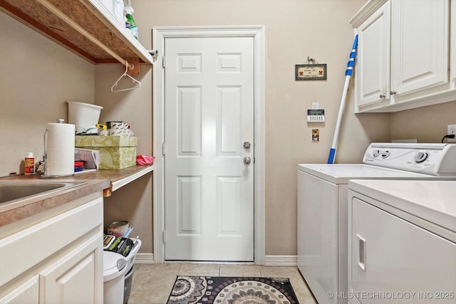 laundry area featuring light tile patterned floors, baseboards, washing machine and dryer, and cabinet space