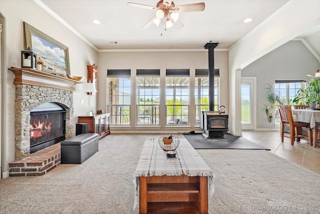 carpeted living area with visible vents, a wood stove, a fireplace, ceiling fan, and recessed lighting