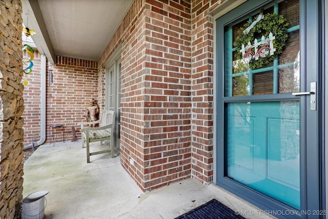 entrance to property featuring brick siding