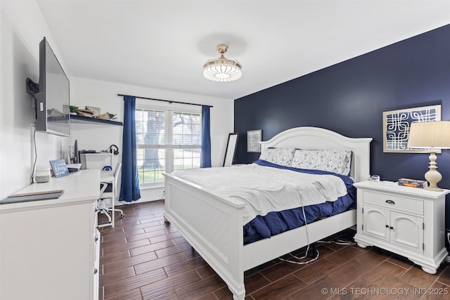bedroom featuring baseboards and wood tiled floor
