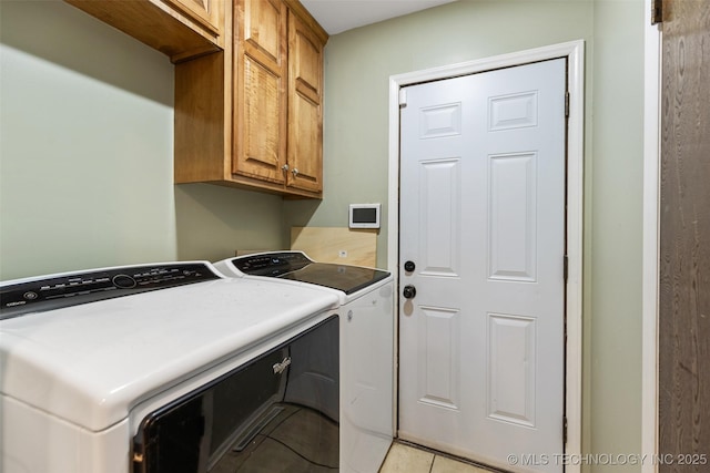 washroom featuring cabinet space, independent washer and dryer, and light tile patterned floors