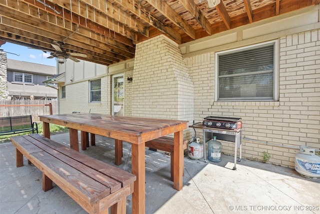 view of patio with fence, outdoor dining area, and a grill