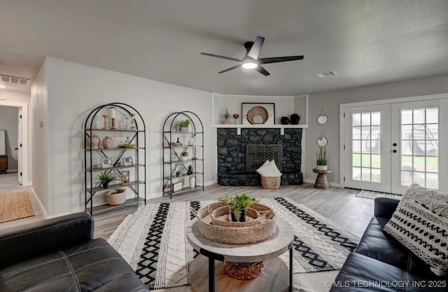 living area with visible vents, baseboards, and ceiling fan