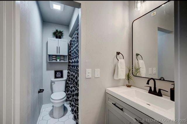 full bathroom with vanity, tile patterned flooring, and toilet