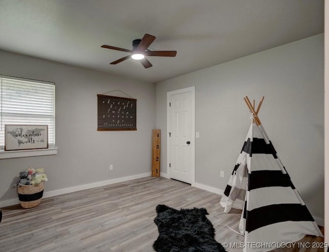 rec room featuring a ceiling fan, baseboards, and wood finished floors