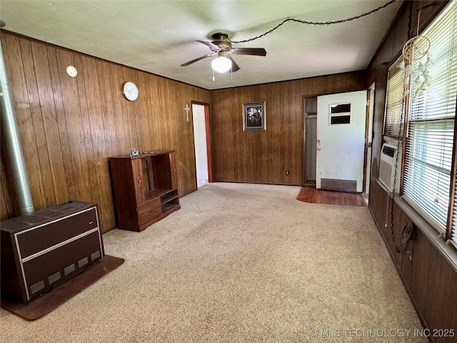 unfurnished living room with ceiling fan, wood walls, light colored carpet, and cooling unit