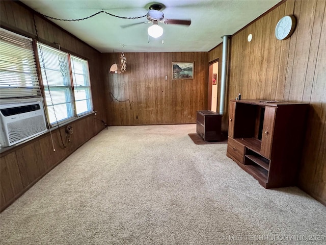 unfurnished living room featuring wooden walls, carpet floors, a ceiling fan, and cooling unit