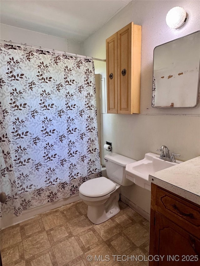 full bath with tile patterned floors, toilet, and a sink