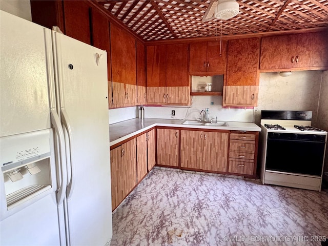 kitchen with white appliances, a sink, and light countertops